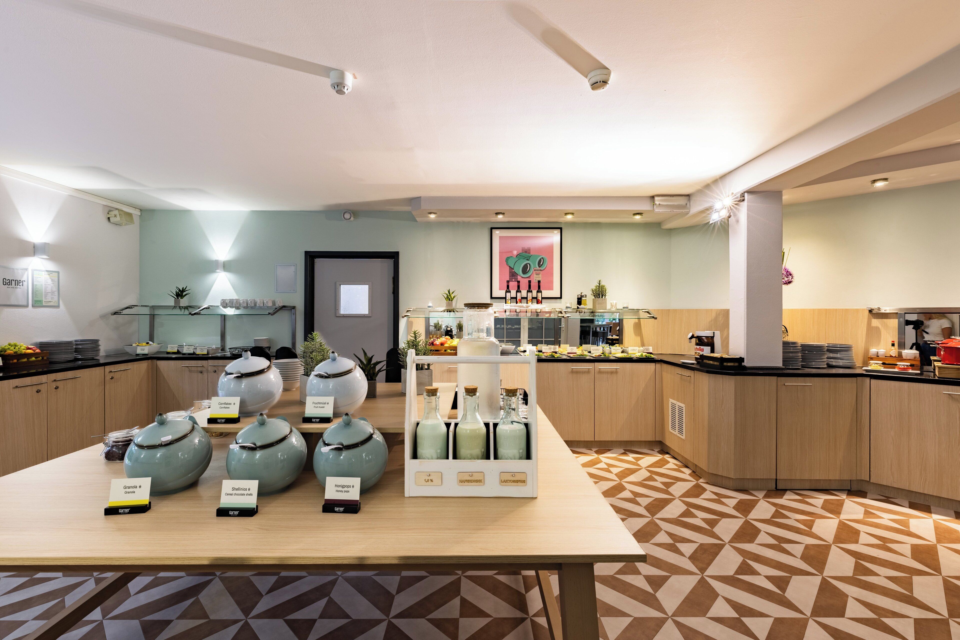 A modern kitchen with a central island displaying food items and a breakfast bar.