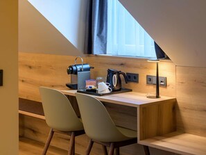 A compact kitchenette with a coffee machine, kettle, and a small table. - Mercure Hotel München Altstadt (Munich)