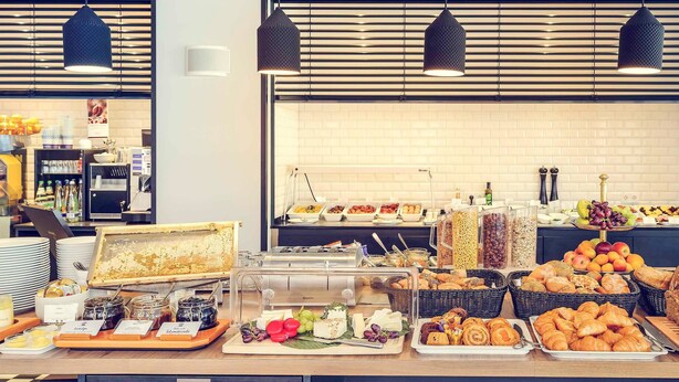 A buffet setup with various food items and a coffee station. - Mercure Hotel München Altstadt (Munich)