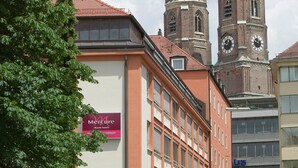 A building with a Mercure hotel sign, a clock tower, and a dome. - Mercure Hotel München Altstadt (Munich)