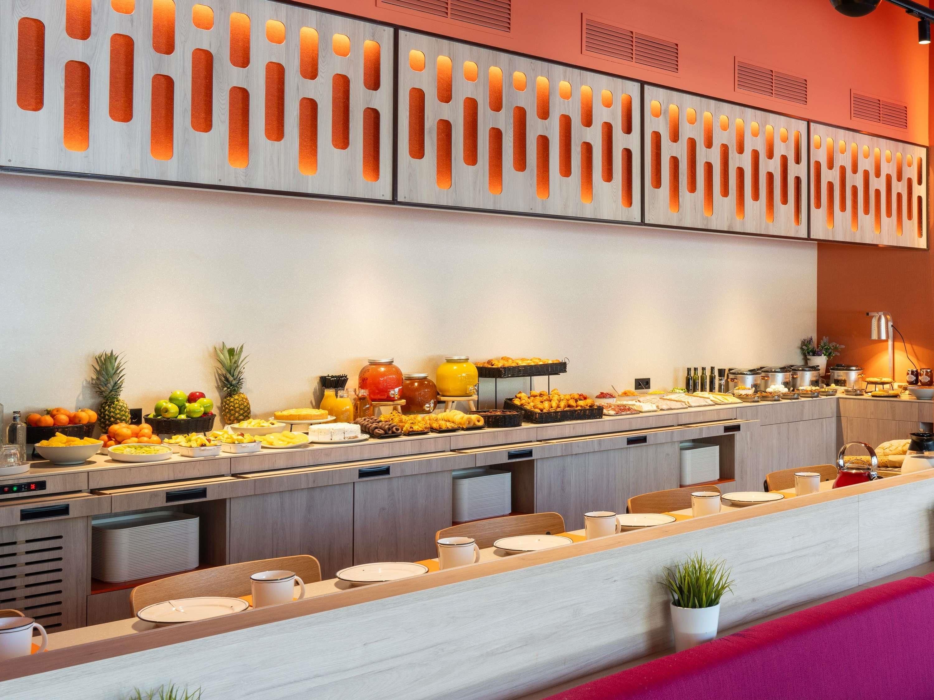 A buffet setup with various food items and a modern kitchen area.