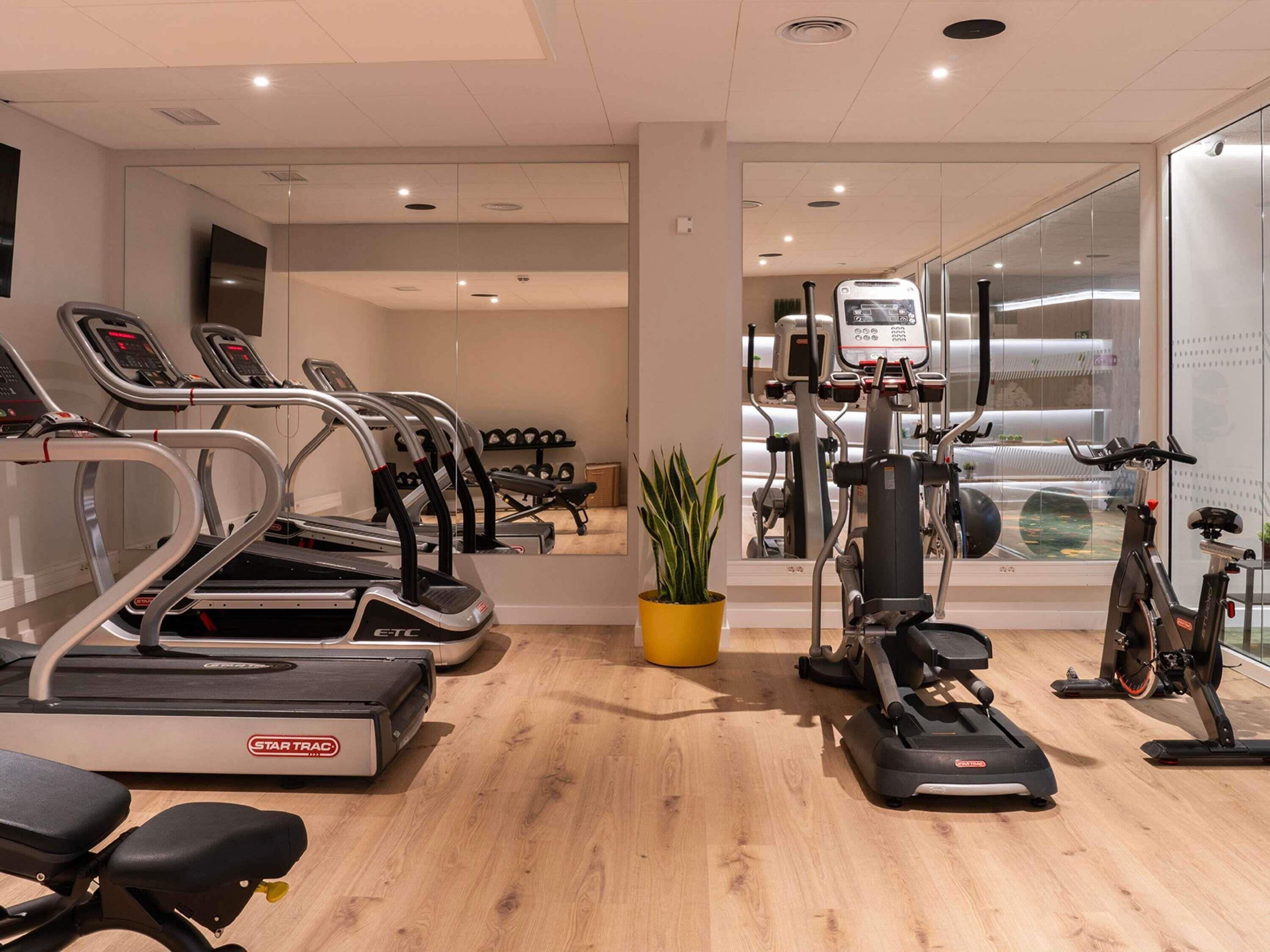 A gym with treadmills, ellipticals, and a stationary bike.