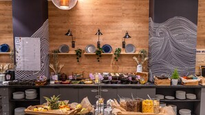 Ein reichhaltiges Buffet mit verschiedenen Speisen, Tellern und Besteck.