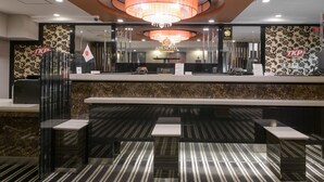 A hotel reception area with a modern design, featuring a marble reception desk, a chandelier, and a flag. - APA Hotel TKP Sapporo Ekimae (Sapporo)
