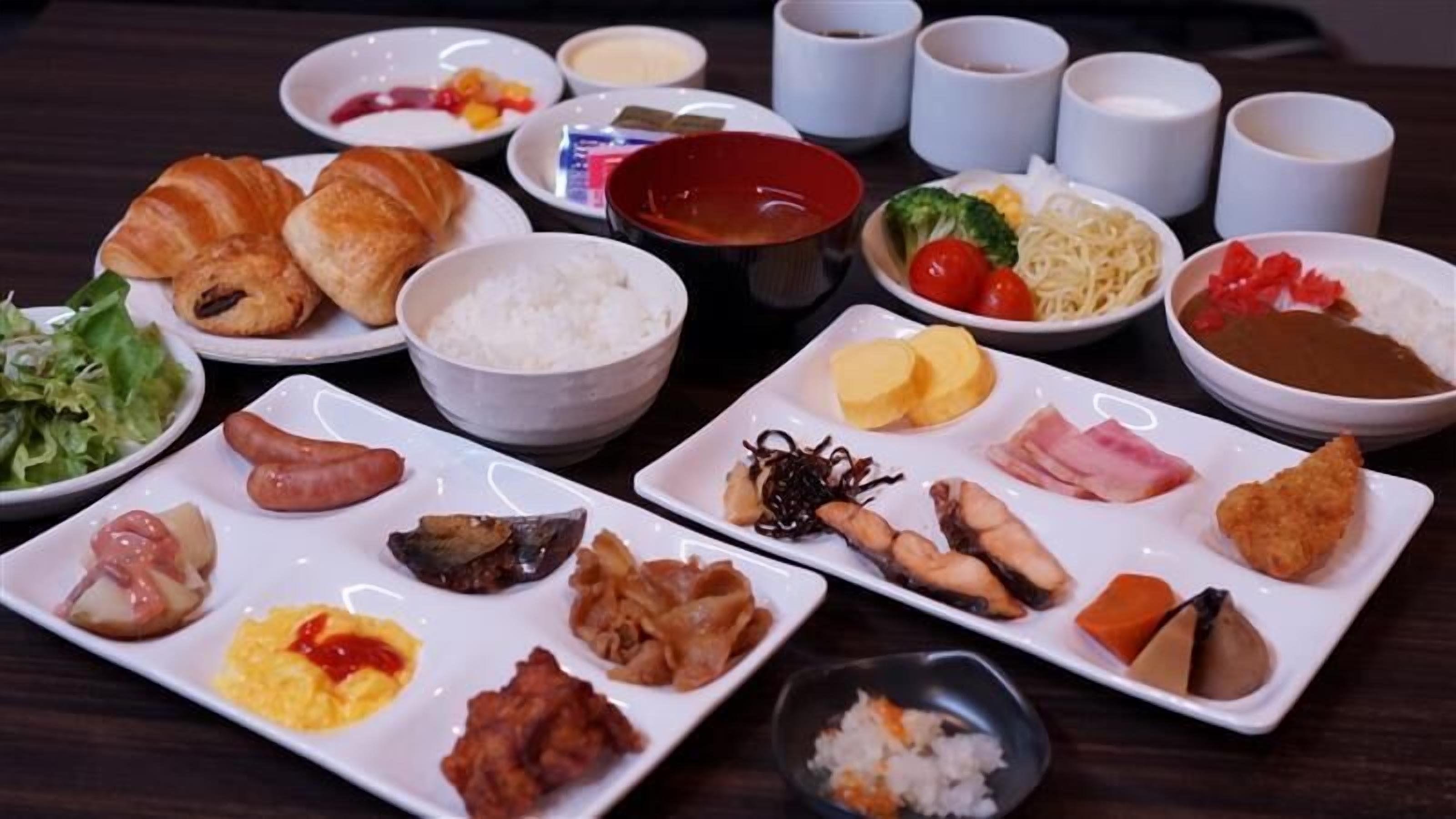 A variety of dishes on a table, including sushi, rice, and different types of meat.