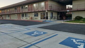 A building with a parking lot marked for disabled parking, a fire hydrant, and a sign indicating the number 25278.