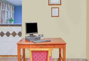 Ein Schreibtisch aus Holz mit einer Computer-Einrichtung, einschließlich Monitor, Tastatur und Lautsprechern.