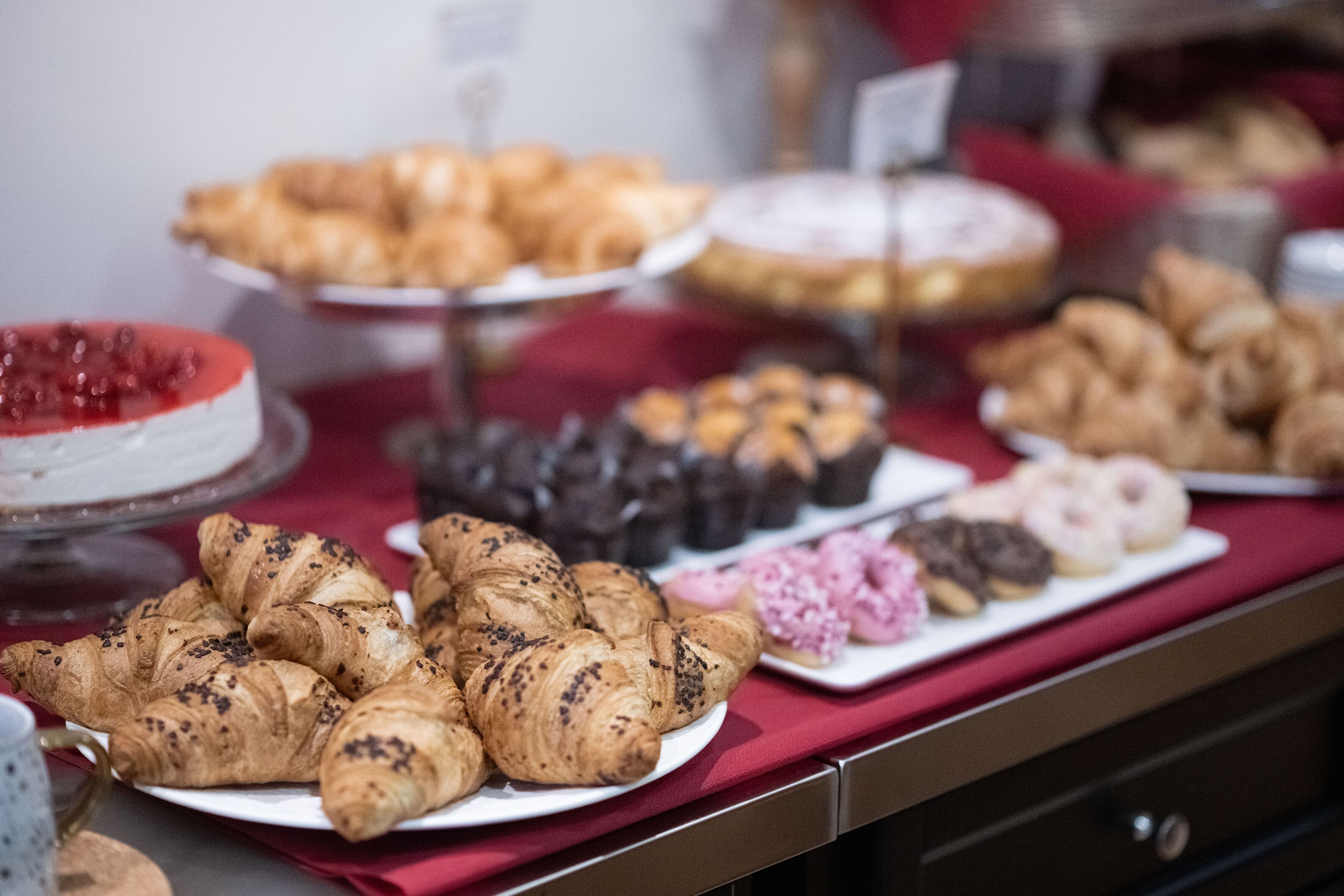 A buffet with various pastries and desserts on display.