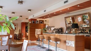 A modern kitchen with a bar area, wooden cabinets, and bar stools. - Charme (Prato)