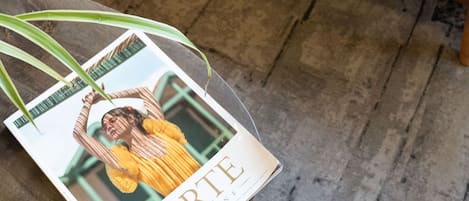 A magazine titled "FORTE" on a coffee table with a plant beside it.
