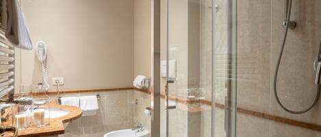 A modern bathroom with a glass-enclosed shower, a vanity with a mirror, and a toilet.