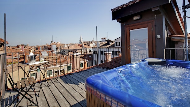 Une terrasse sur le toit avec un jacuzzi, une terrasse en bois et une vue sur le paysage urbain.