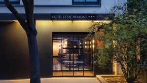 The exterior of Hotel Le Richemont with a modern facade, glass entrance, and a tree in the foreground. - Hôtel Le Richemont (Paris)