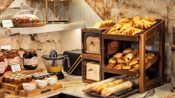 A breakfast buffet with various breads, pastries, and fruits. - Hôtel Le Richemont (Paris)