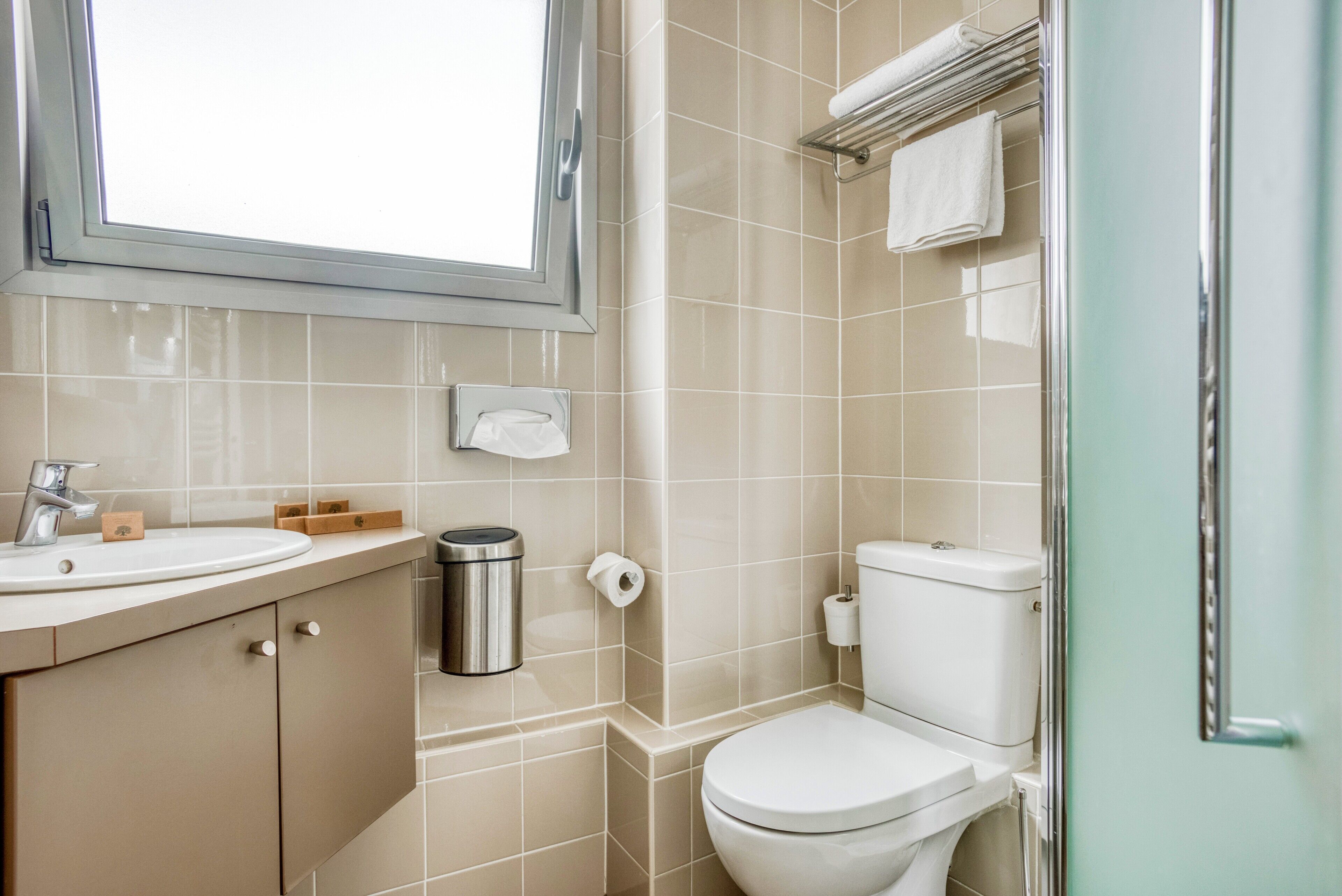 Un baño con inodoro, lavamanos y espejo.