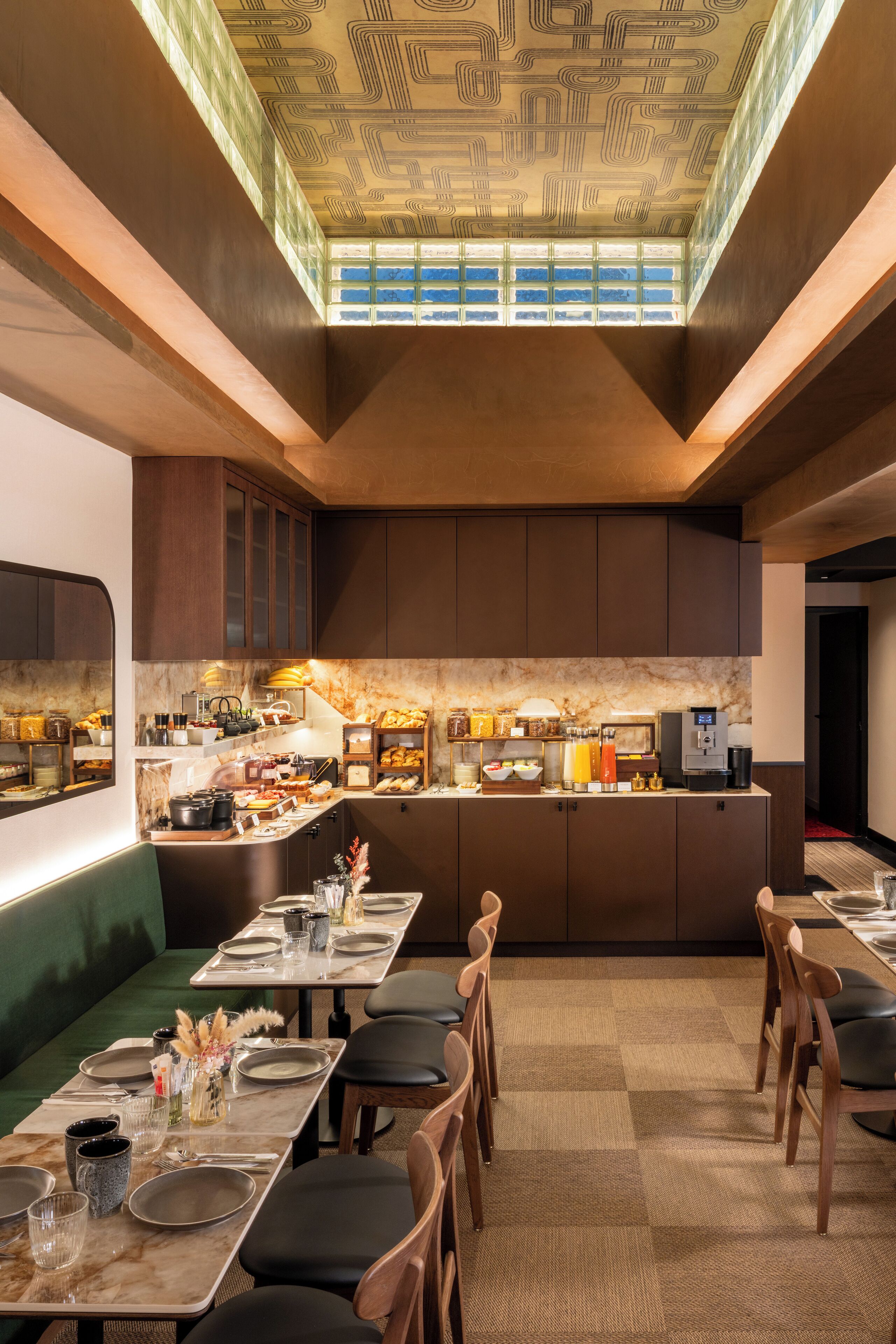 A modern restaurant with a high ceiling, a central serving area, and a seating arrangement with tables and chairs.