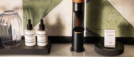A bathroom vanity with a marble backsplash, a glass jar, and three bottles of Codage Paris hair care products.