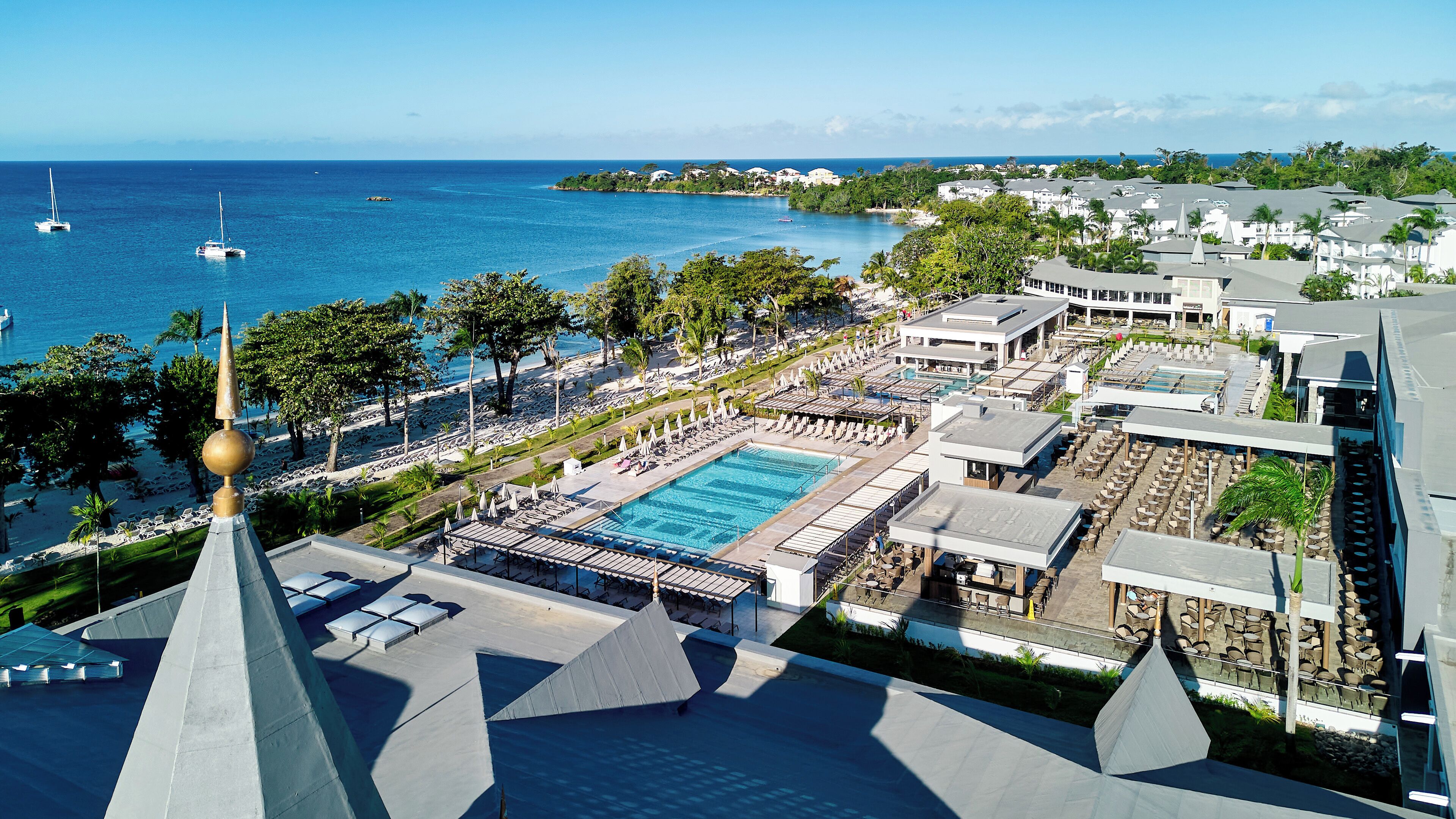 Un complexe hôtelier doté d’une piscine, d’une plage et offrant une vue sur l’océan.