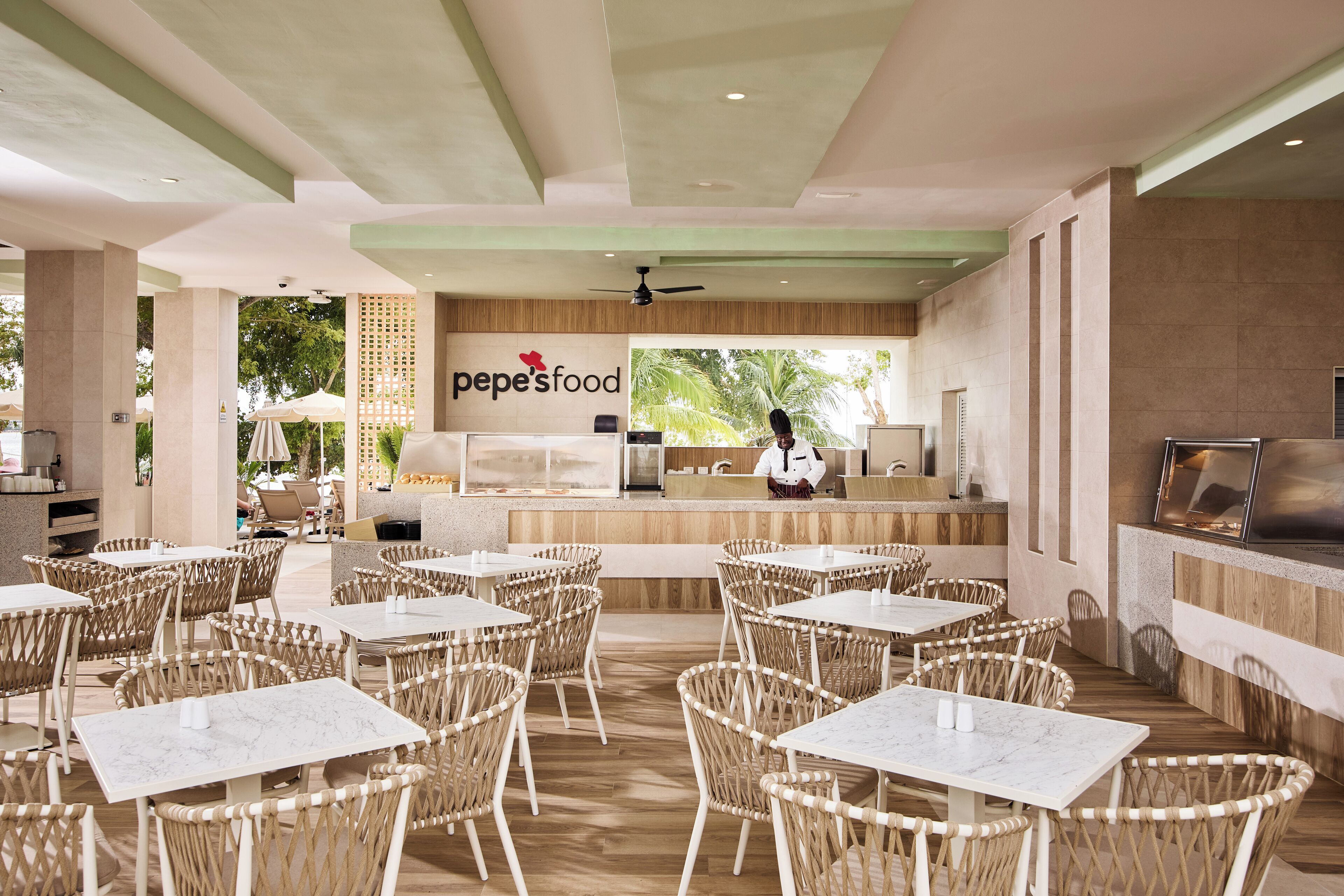 Un restaurant avec une terrasse, un comptoir où l’on peut observer le chef à l’œuvre, et une vue sur la verdure.