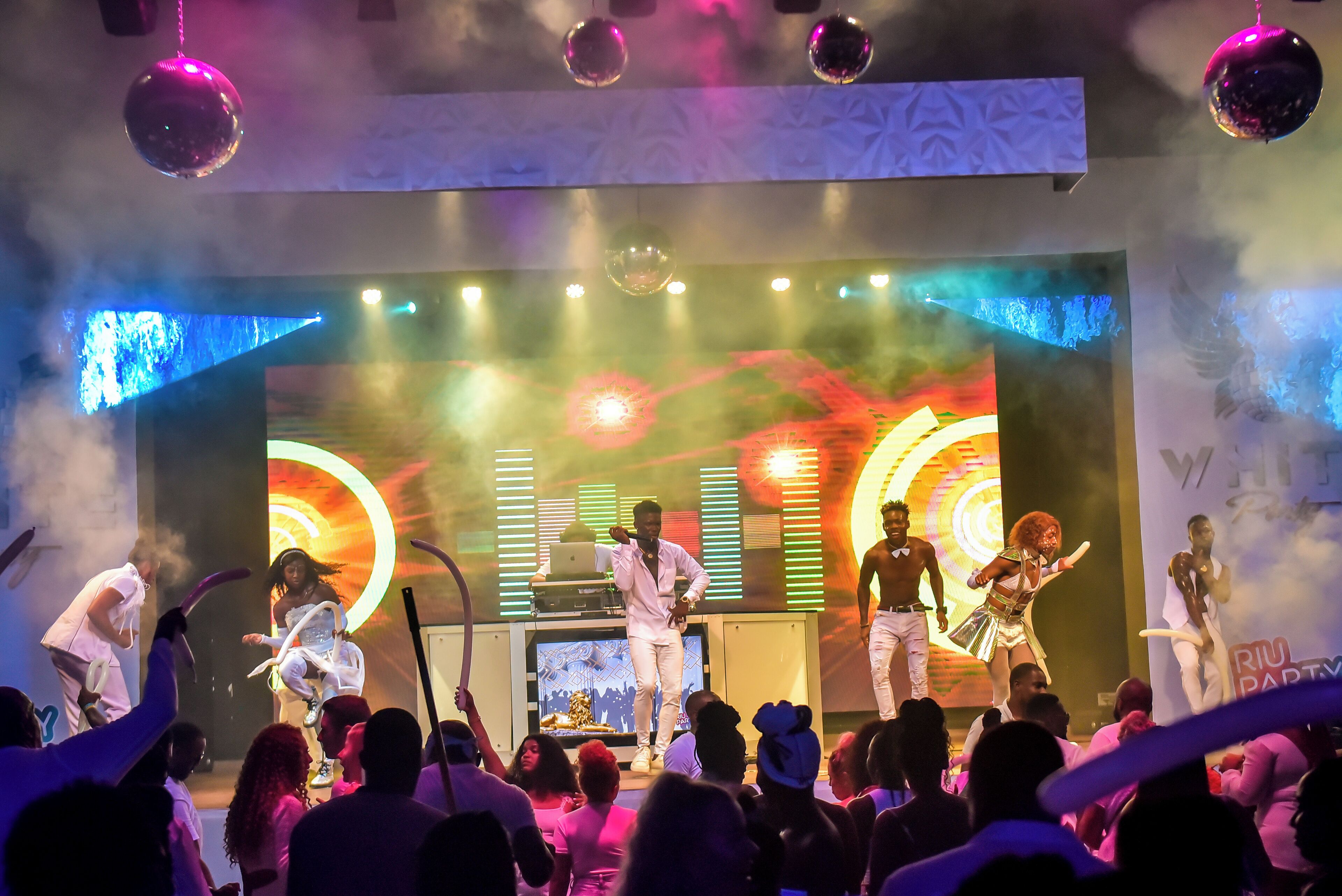 A stage with performers and a crowd.