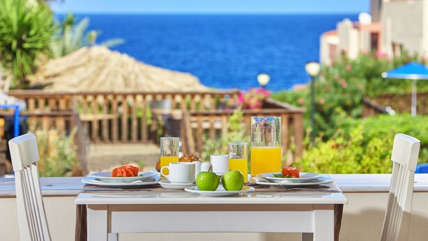 Una tavola apparecchiata per la colazione con vista sull'oceano.