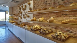 Una vetrina di panetteria con diversi tipi di pane e dolci.