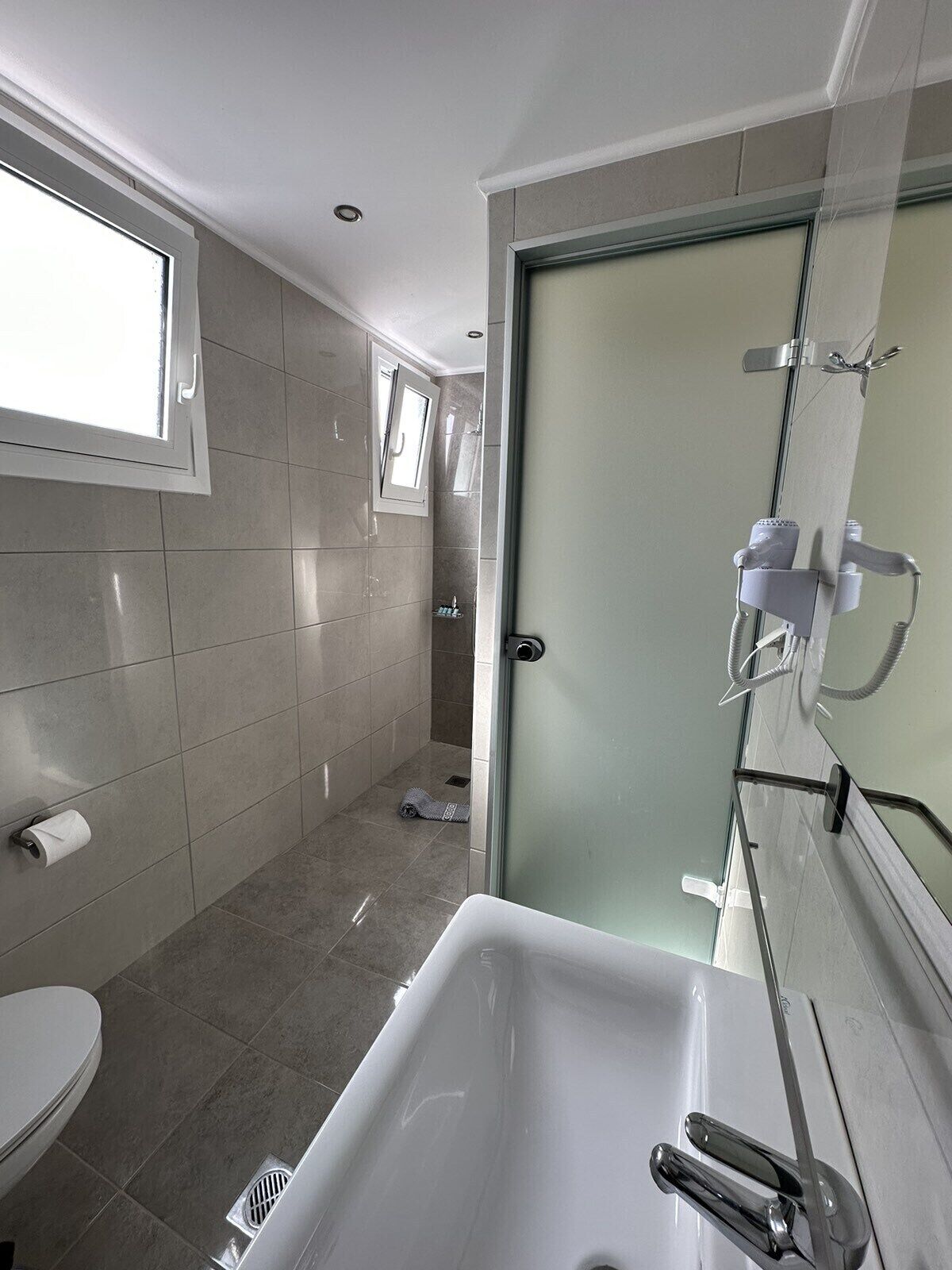 A modern bathroom with a large bathtub, a toilet, and a shower area.