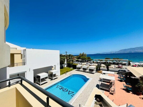 Relax by the pool surrounded by a deck and lounge chairs, with breathtaking views of the sea and mountains.