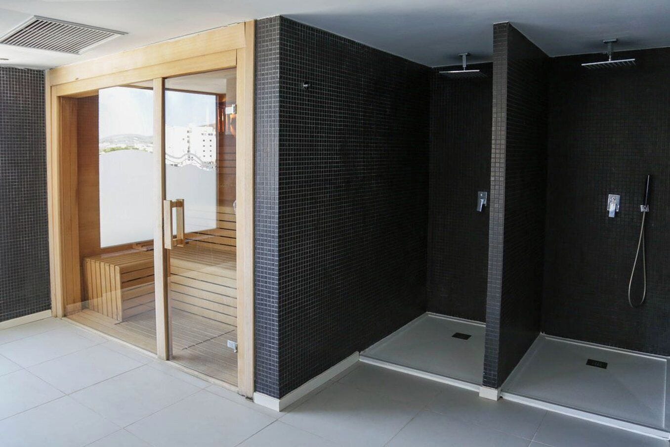Un bagno moderno con doccia, un water e una porta vetrata che dà su un'area esterna.
