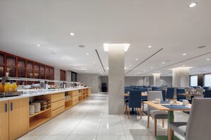 A modern cafe with a long counter, seating area, and a large pillar. - Eurostars Puerto de Ibiza (Ibiza Town)