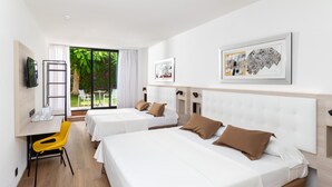 Habitación de hotel con dos camas, un escritorio, una silla y un televisor.