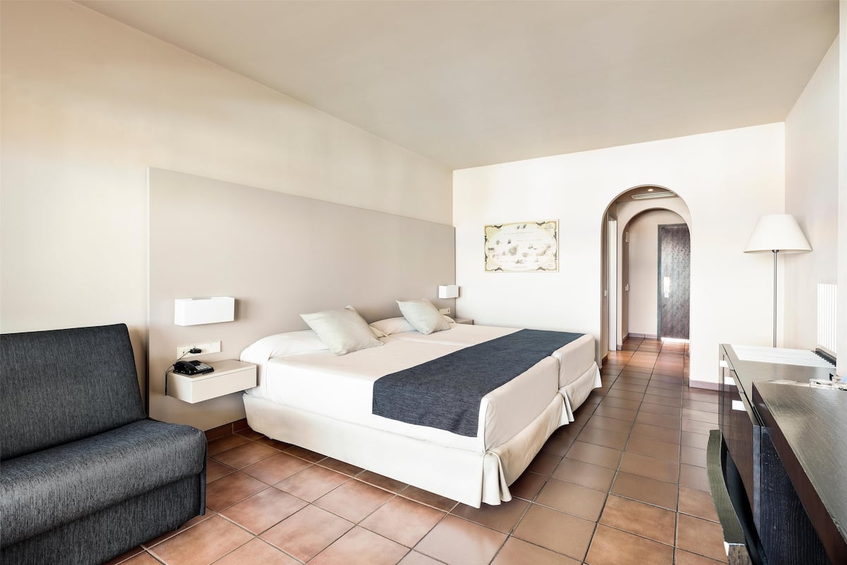 Una habitación de hotel con cama, sofá, escritorio y baño.
