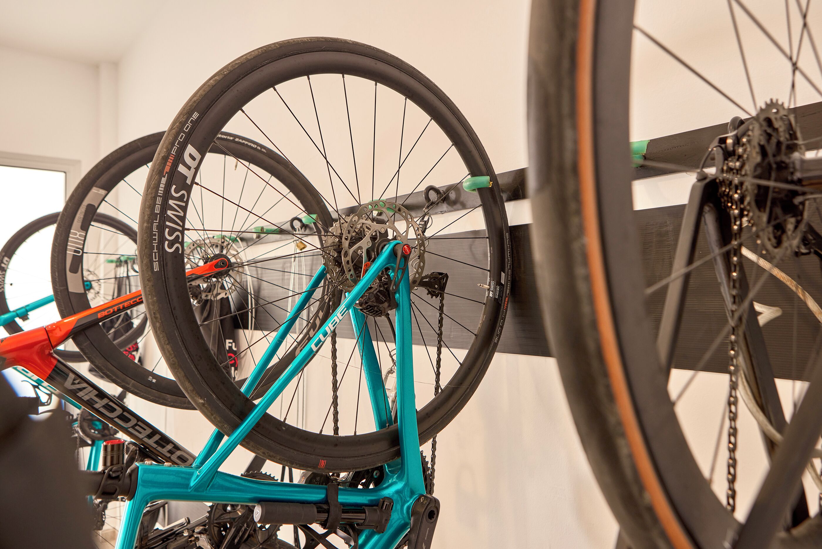 A bicycle with a turquoise frame and black tires mounted on a wall.