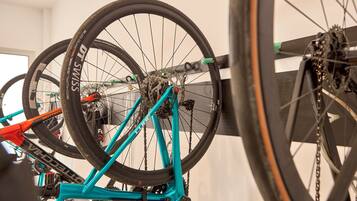 A bicycle with a turquoise frame and black tires mounted on a wall.