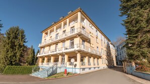 Un immeuble à plusieurs étages doté de balcons, d’un escalier et d’une borne d’incendie rouge.