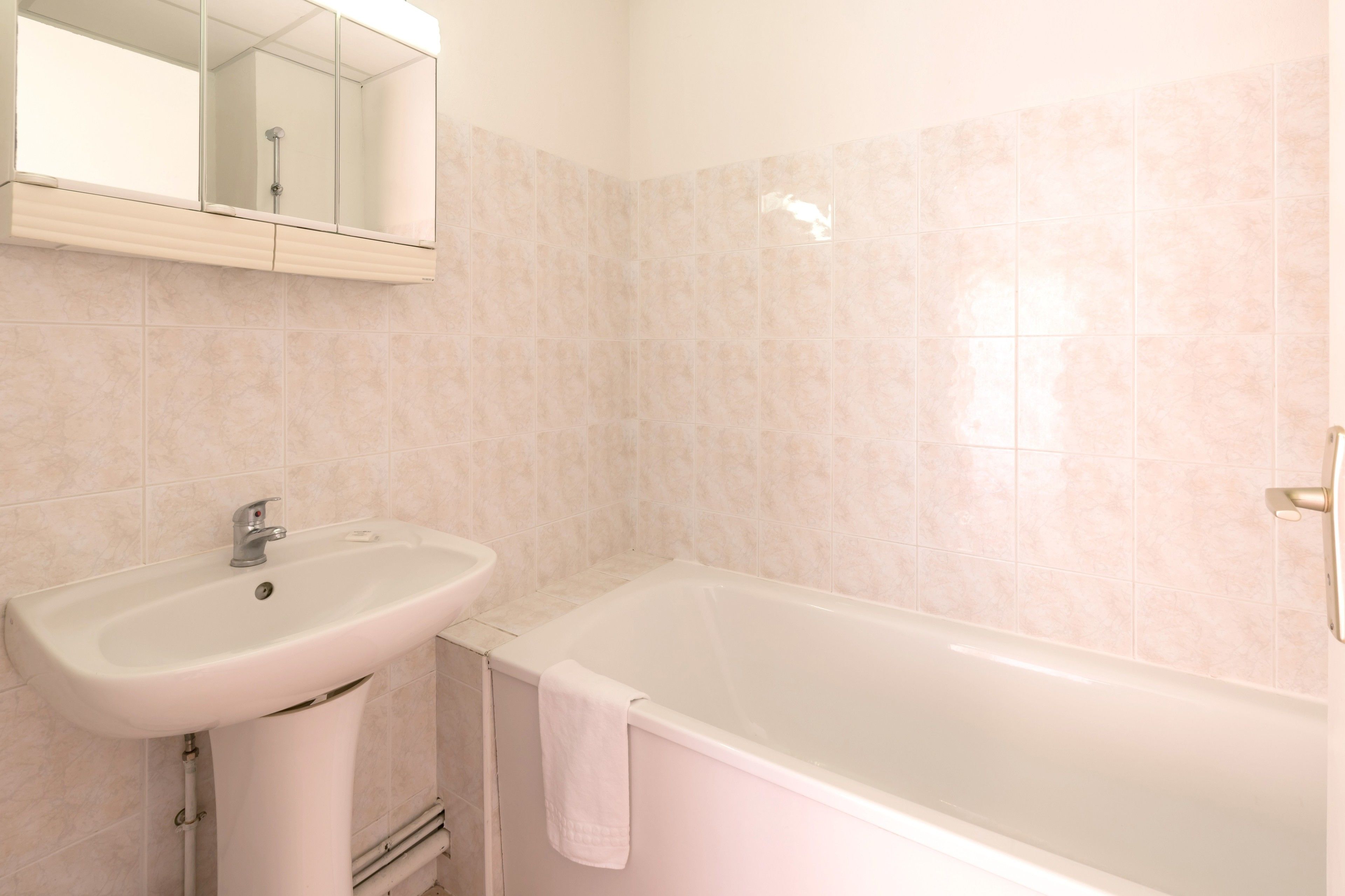Un baño con lavamanos, espejo y bañera.