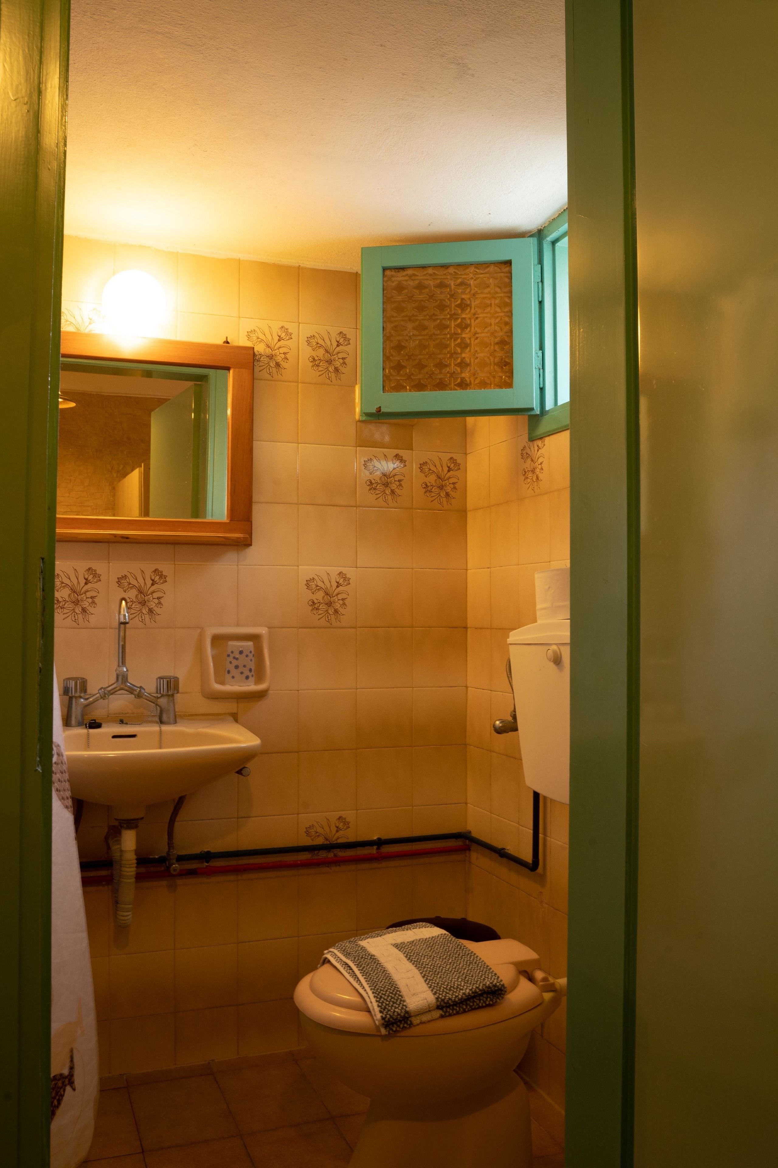 A bathroom with a sink, toilet, and mirror.