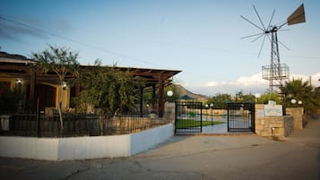 A gated entrance to a property with a windmill, a reception desk, and a sign indicating it's a resort hotel.