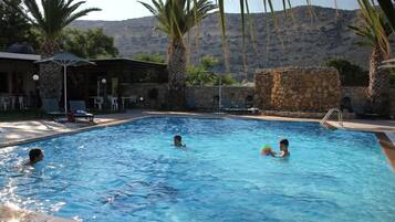 Relax by the pool surrounded by lush palm trees and breathtaking mountain views.
