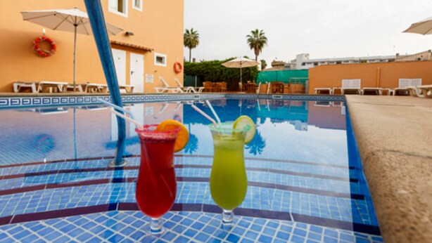 Un espace aménagé au bord de la piscine, avec des chaises longues et des parasols.