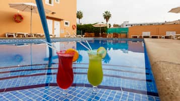 Una piscina al aire libre, sombrillas, tumbonas