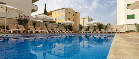 Piscine extérieure, parasols de plage, chaises longues