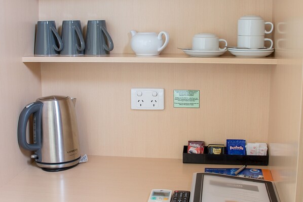 A hotel reception area with a coffee station, tea set, and a kettle. - Miami Hotel Melbourne (West Melbourne)