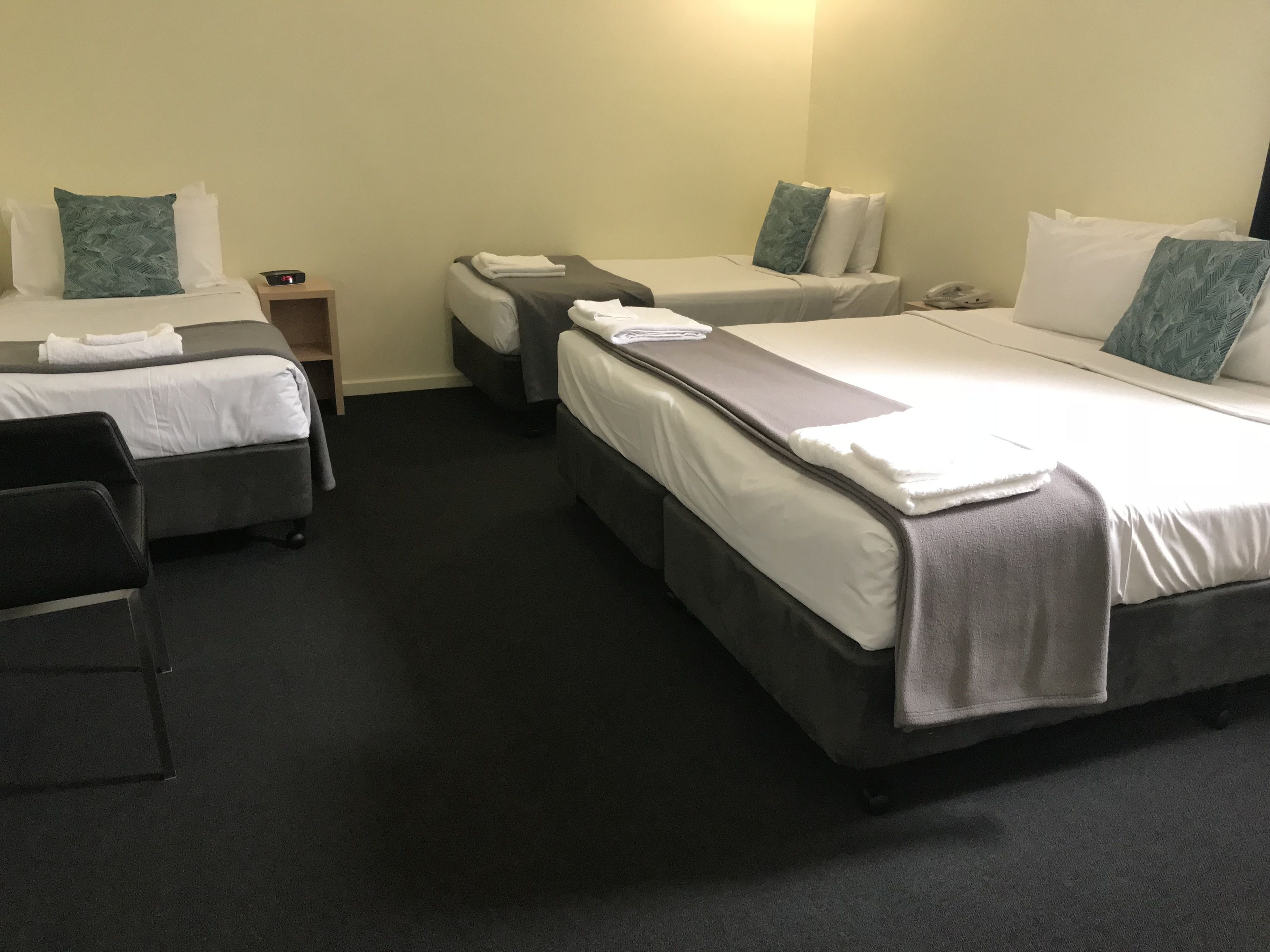 Une chambre d’hôtel avec deux lits simples, un bureau et une chaise.