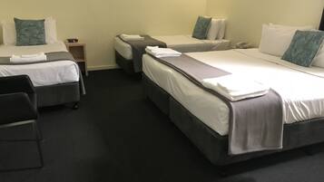 Una habitación de hotel con dos camas individuales, un escritorio y una silla.