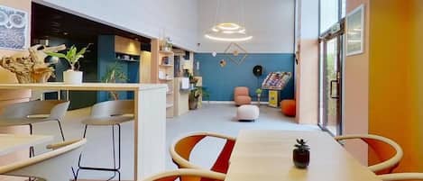 A modern interior with a long dining table, chairs, and a blue accent wall.
