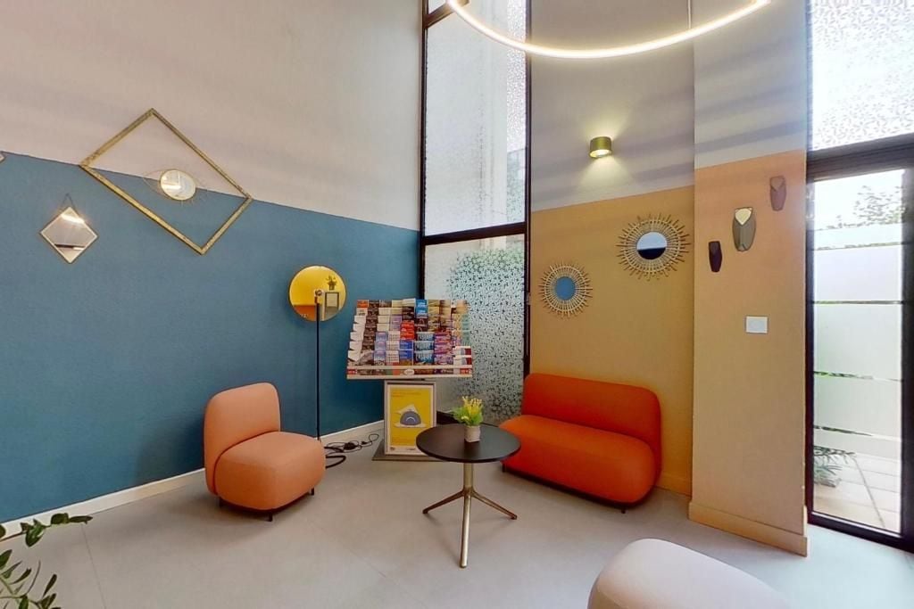 Un interior moderno con una pared azul, muebles naranjas y una pequeña mesa con una planta.