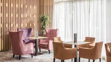 A modern room with a wooden slat wall, a potted plant, and a table with chairs.