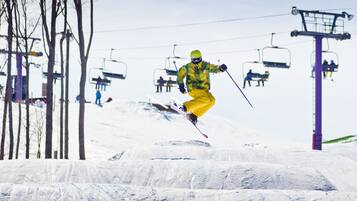 Een skilift met stoelen en een skiër in de lucht.