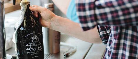 Una persona vertiendo cerveza de Shorts Brewing Company en un grifo.
